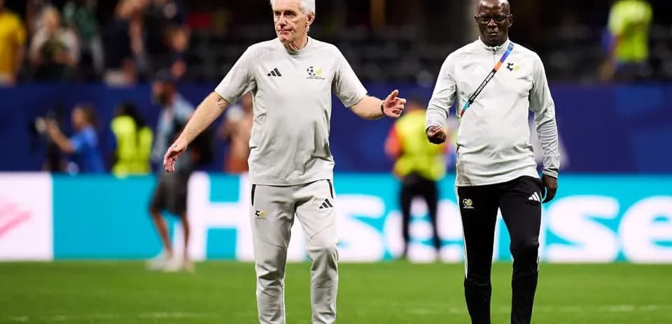 Two coaches walking on the pitch before match