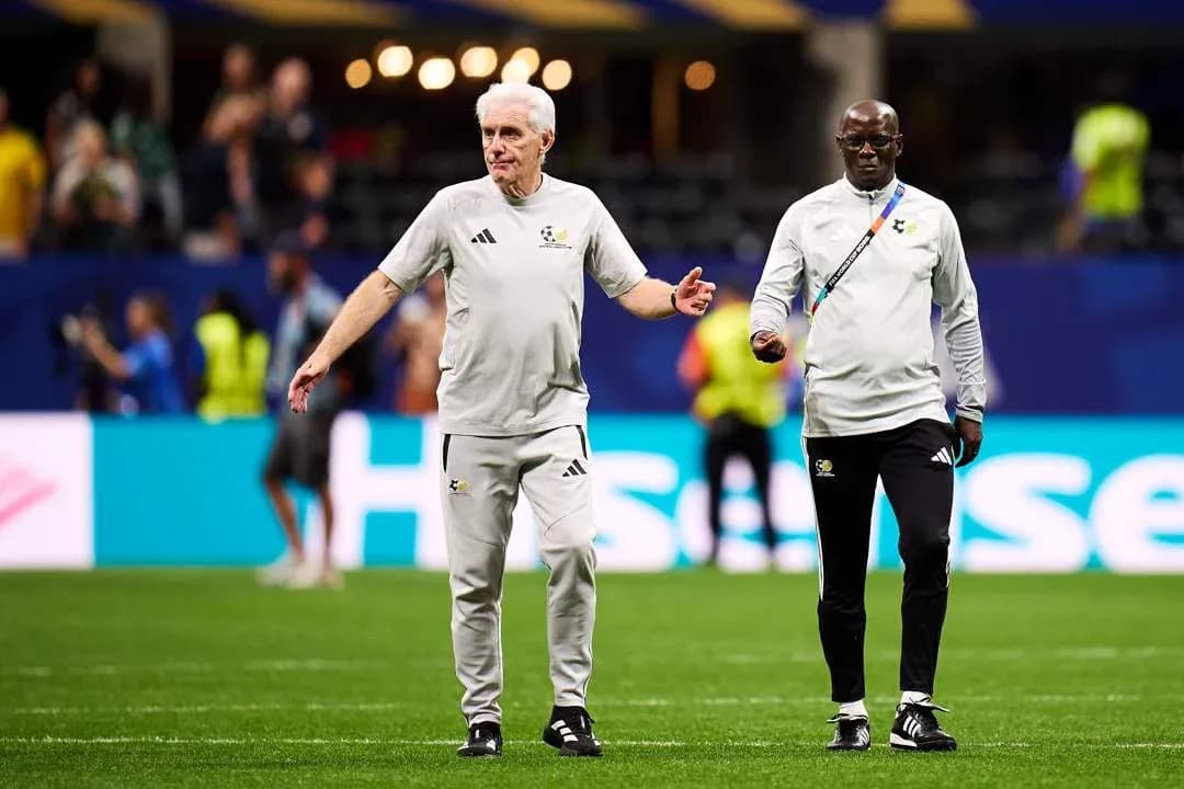 Two coaches walking on the pitch before match