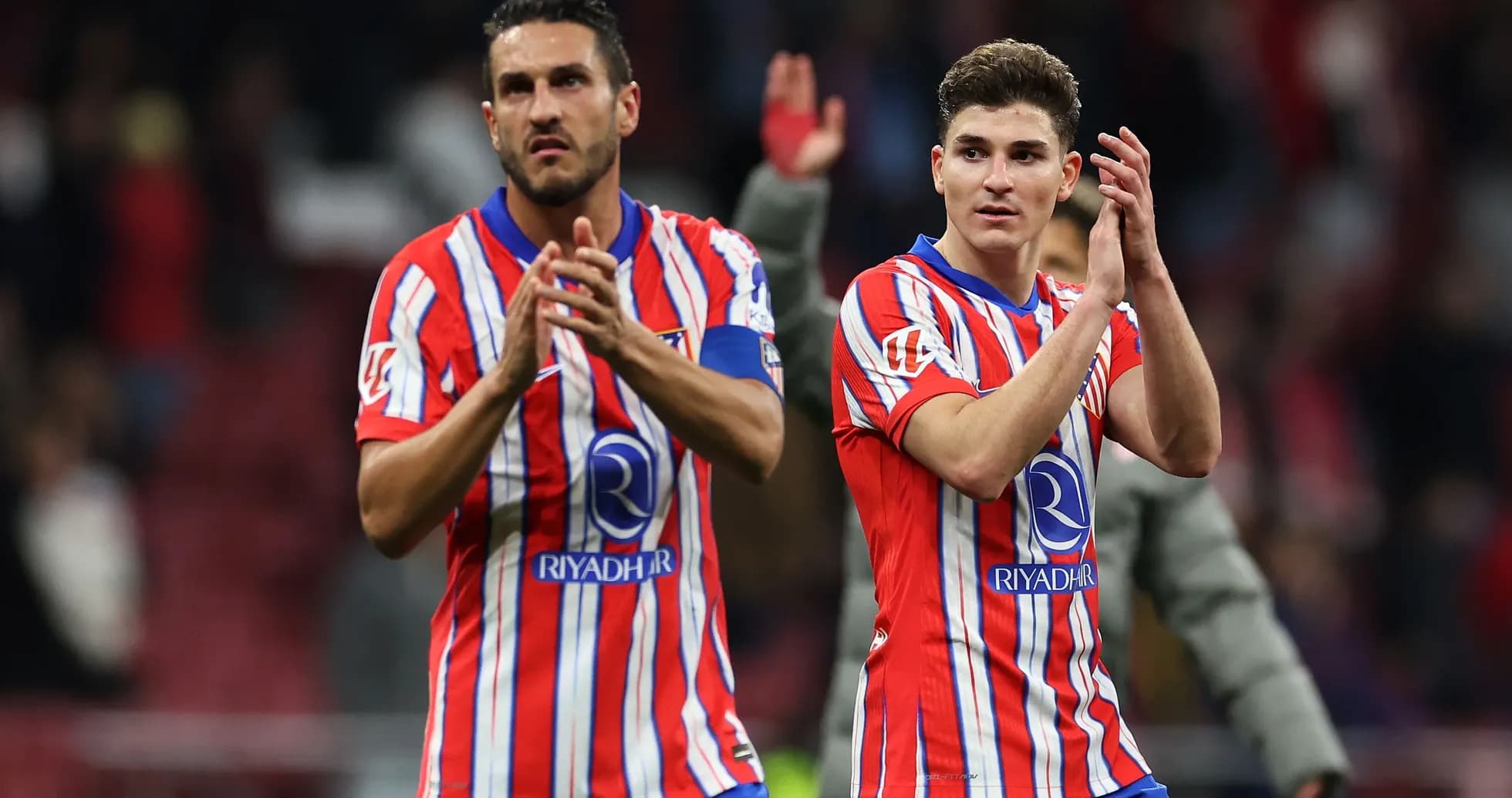 Two players applauding fans after the match