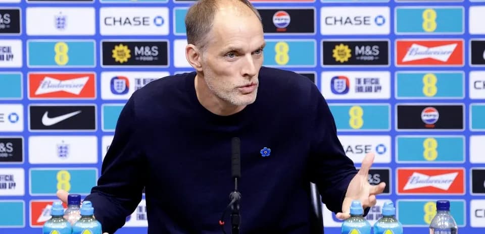 Coach speaking at press conference with water bottles