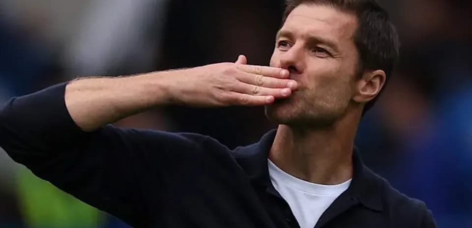 Coach blowing a kiss to fans during match