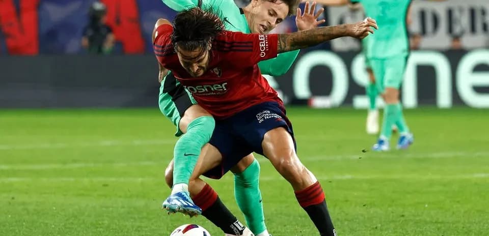 Osasuna player battling for the ball against Atletico Madrid