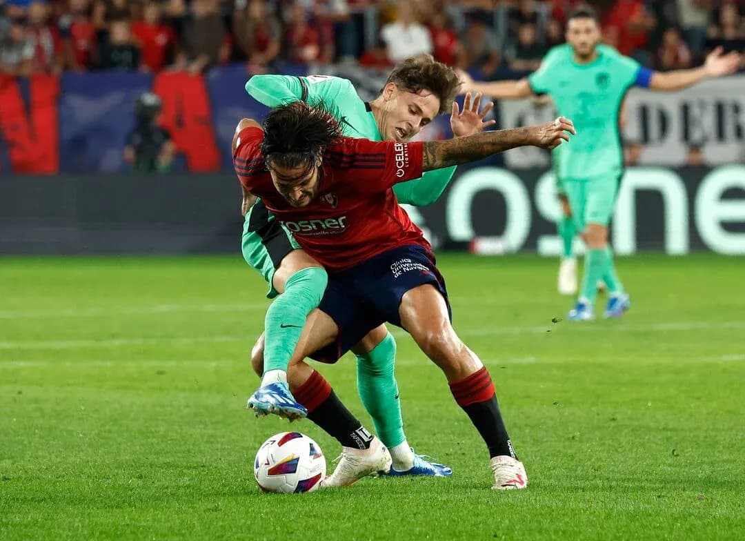 Osasuna player battling for the ball against Atletico Madrid