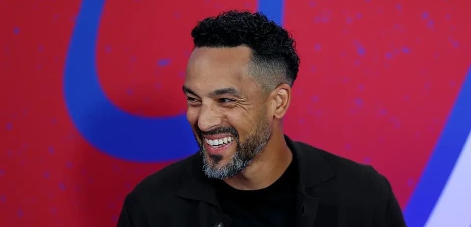 Man smiling during an interview on stage