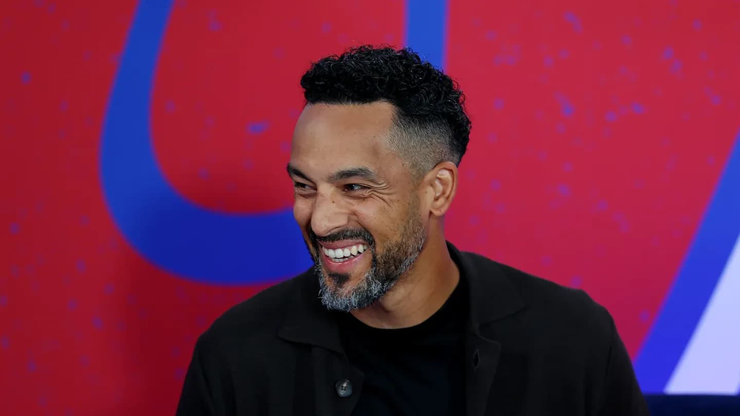 Man smiling during an interview on stage