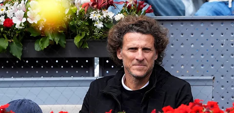 Man sitting in stands with flowers around him