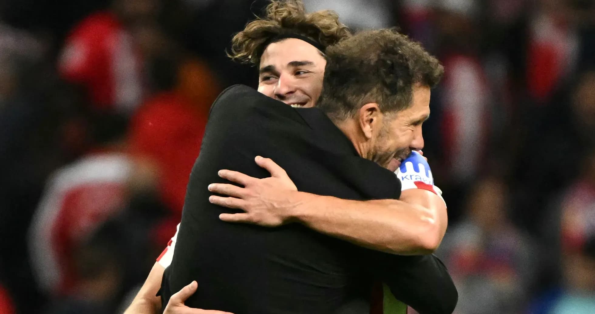Players celebrating with a hug after victory