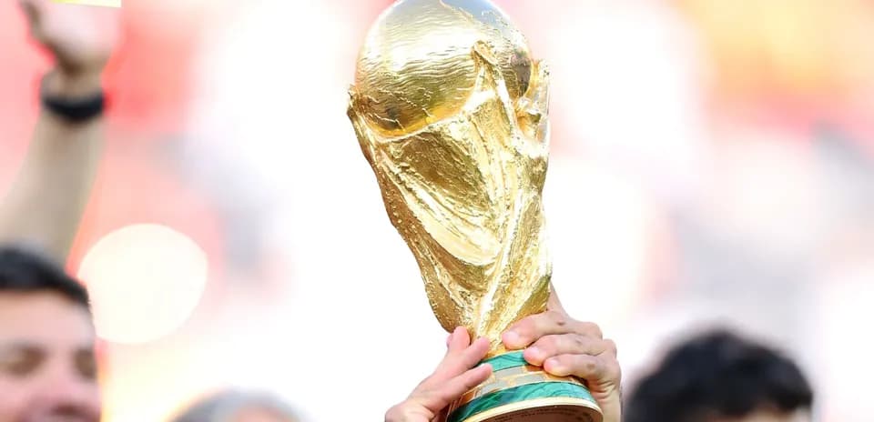 Golden FIFA World Cup trophy being held aloft