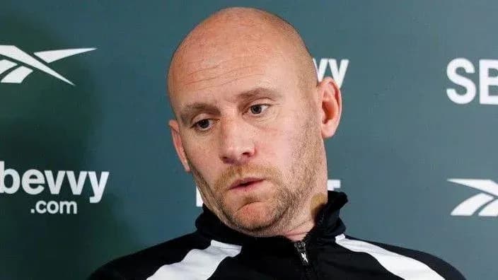 Manager at press conference with serious expression