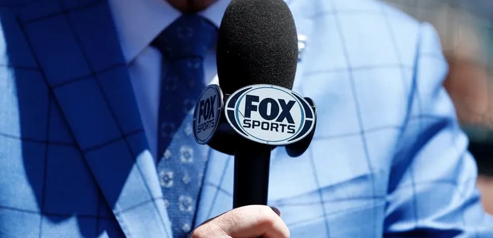 Person holding a microphone with FOX Sports logo