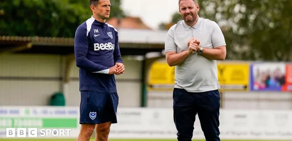 Two coaches discussing on the training pitch