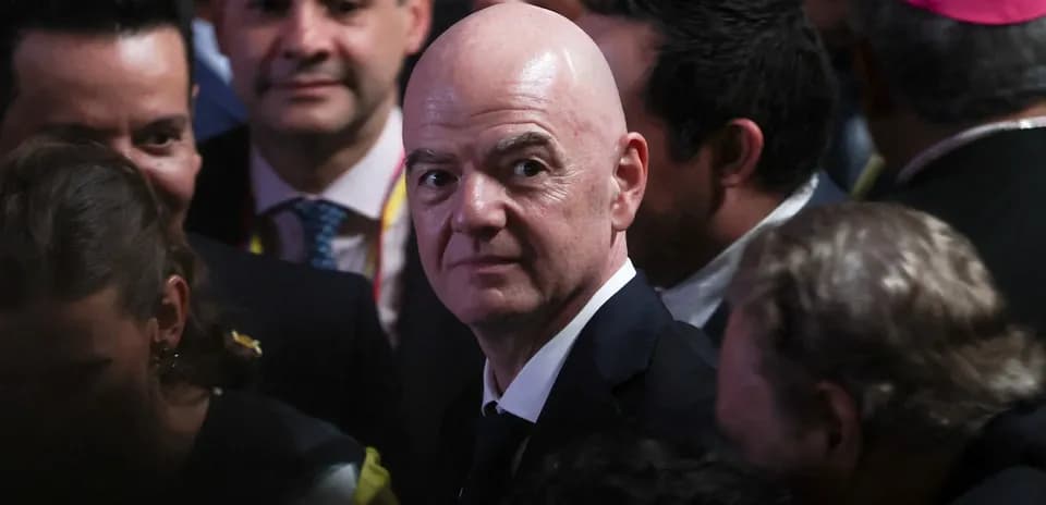 Man in suit surrounded by crowd at event