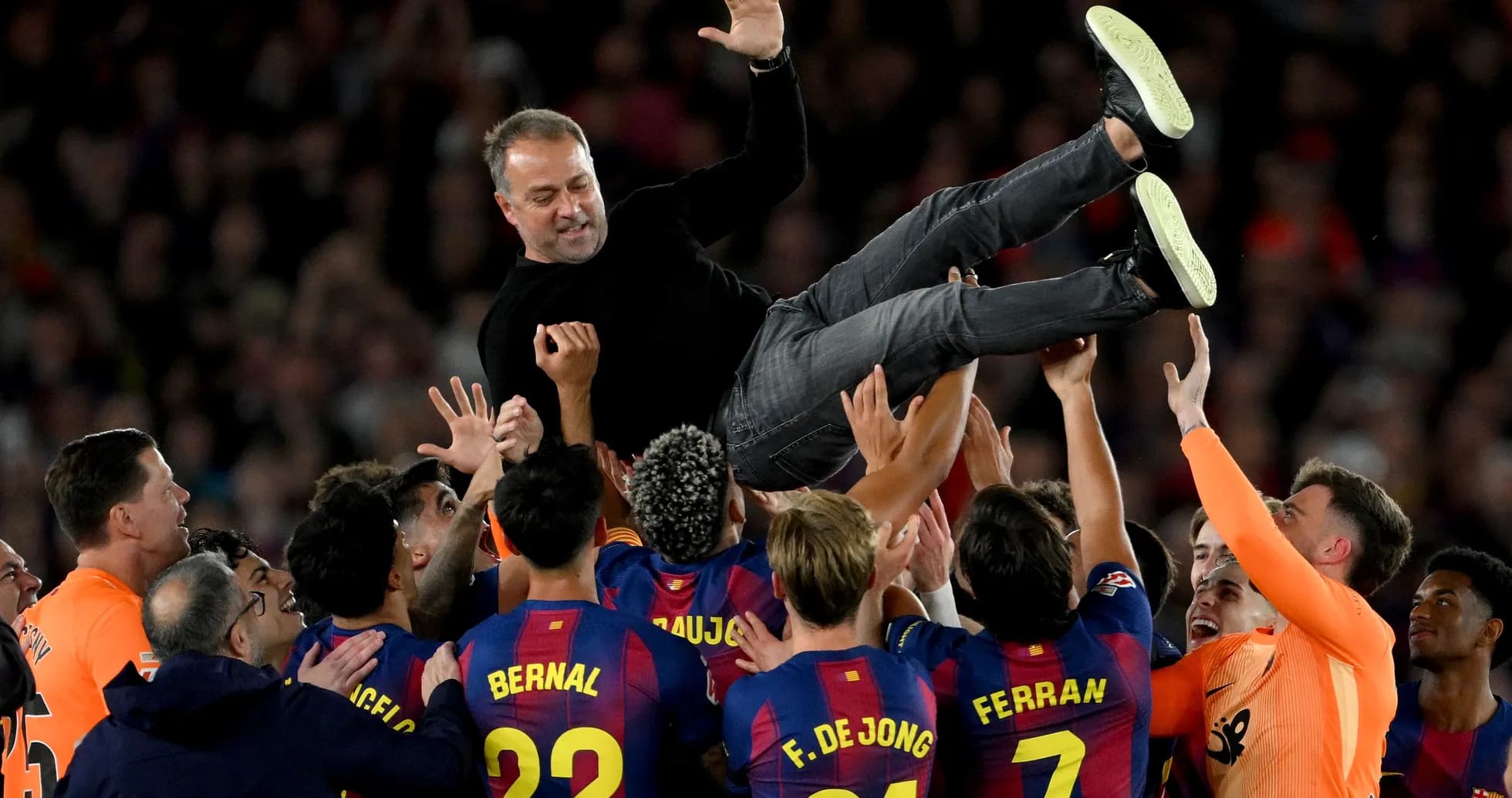 Barcelona team celebrating by lifting their coach