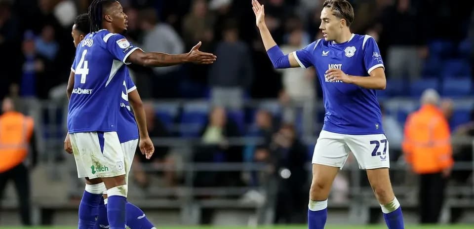 Two Cardiff City players celebrating a goal on pitch