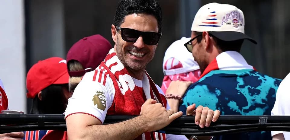 Man in sunglasses smiling with Arsenal scarf