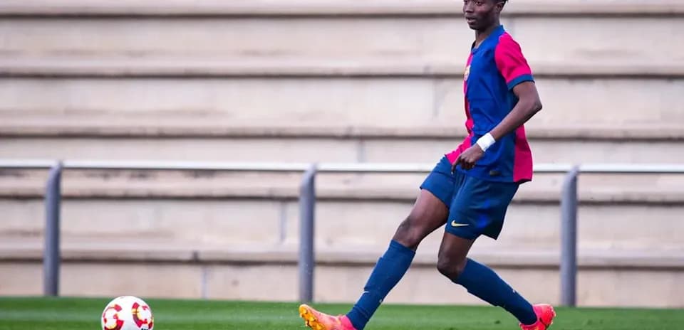 Player in FC Barcelona kit dribbling ball on field