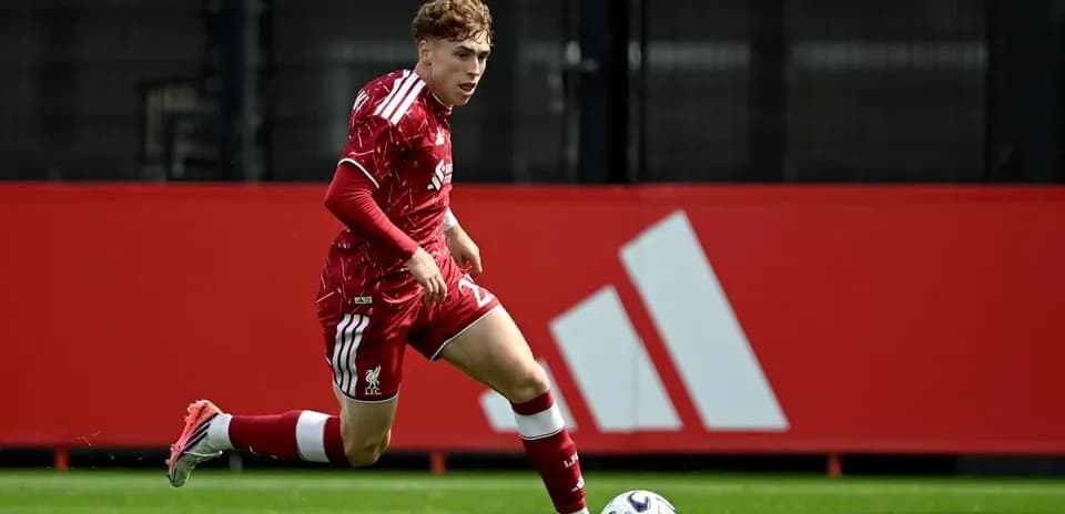 Player in red kit sprinting towards the ball