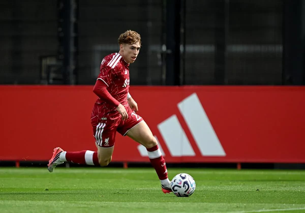Player in red kit sprinting towards the ball