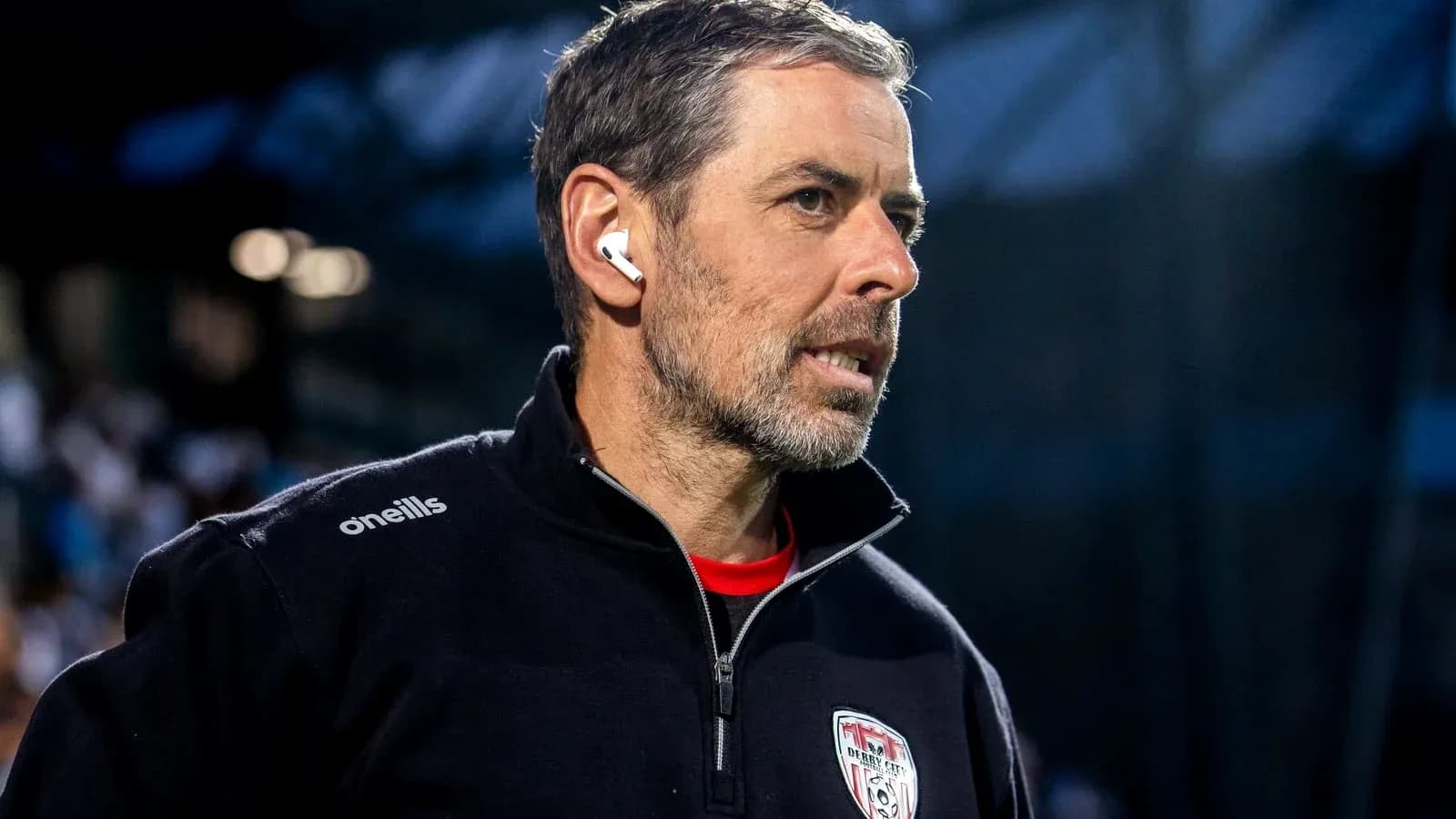 Coach wearing earbuds during match preparation