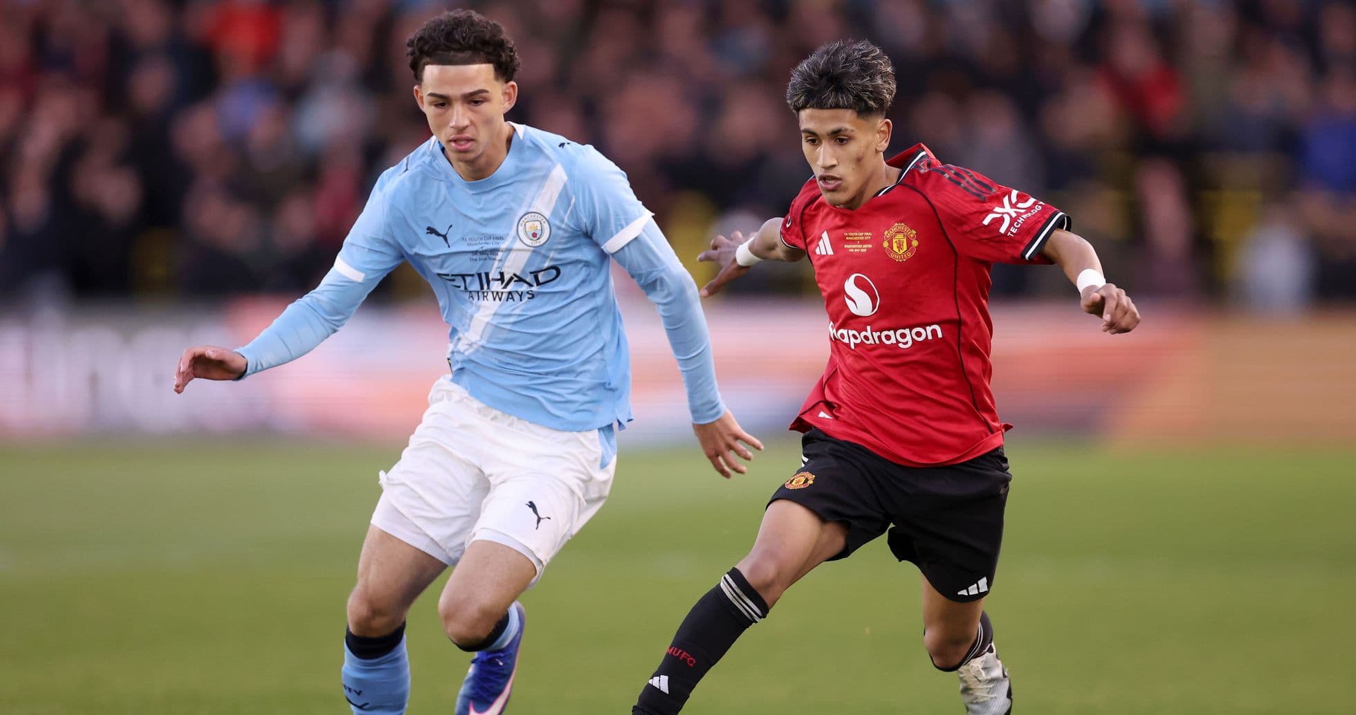 Players from Manchester City and Manchester United competing for the ball