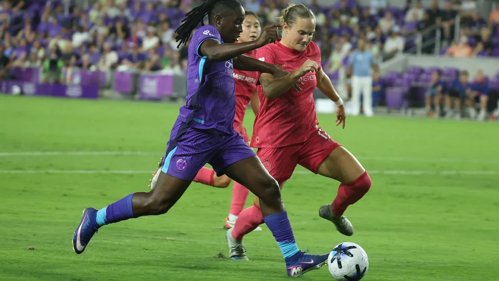 Orlando Pride player dribbling the ball against Boston Legacy