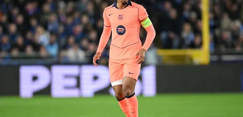 Player in pink kit dribbling ball on pitch