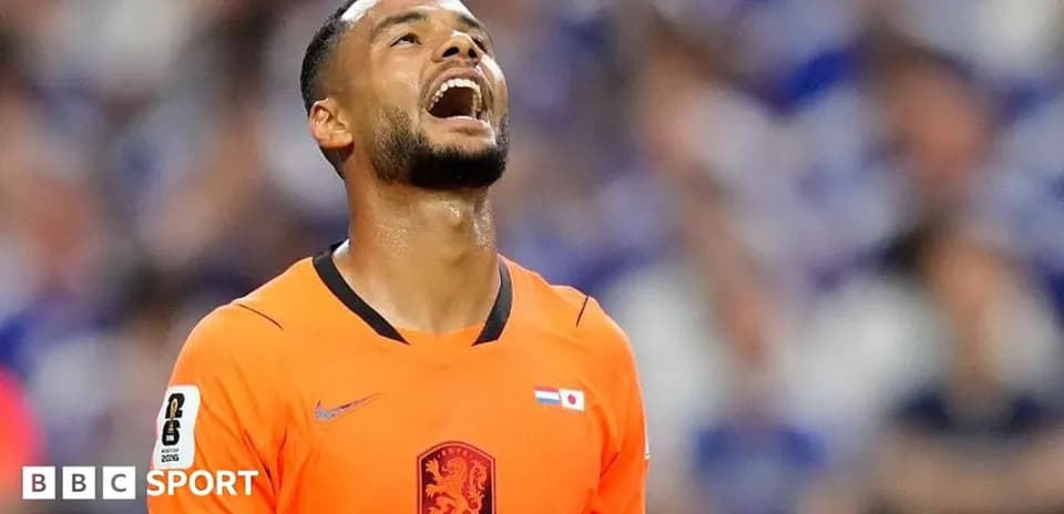 Player in orange kit looking up during match