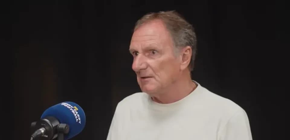 Man speaking at a microphone in studio setting