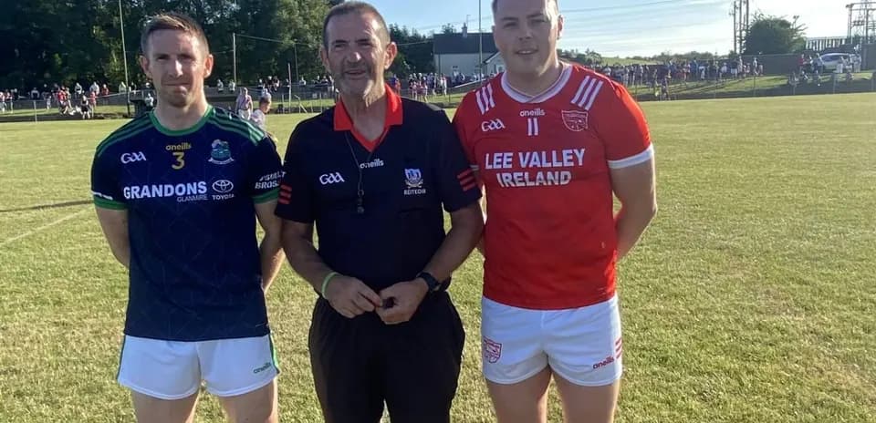Two players and referee posing on the field