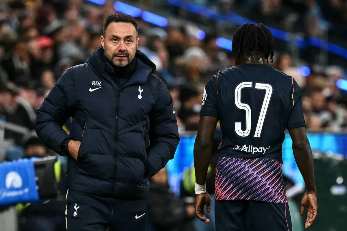 Tottenham coach discussing strategy with player on pitch