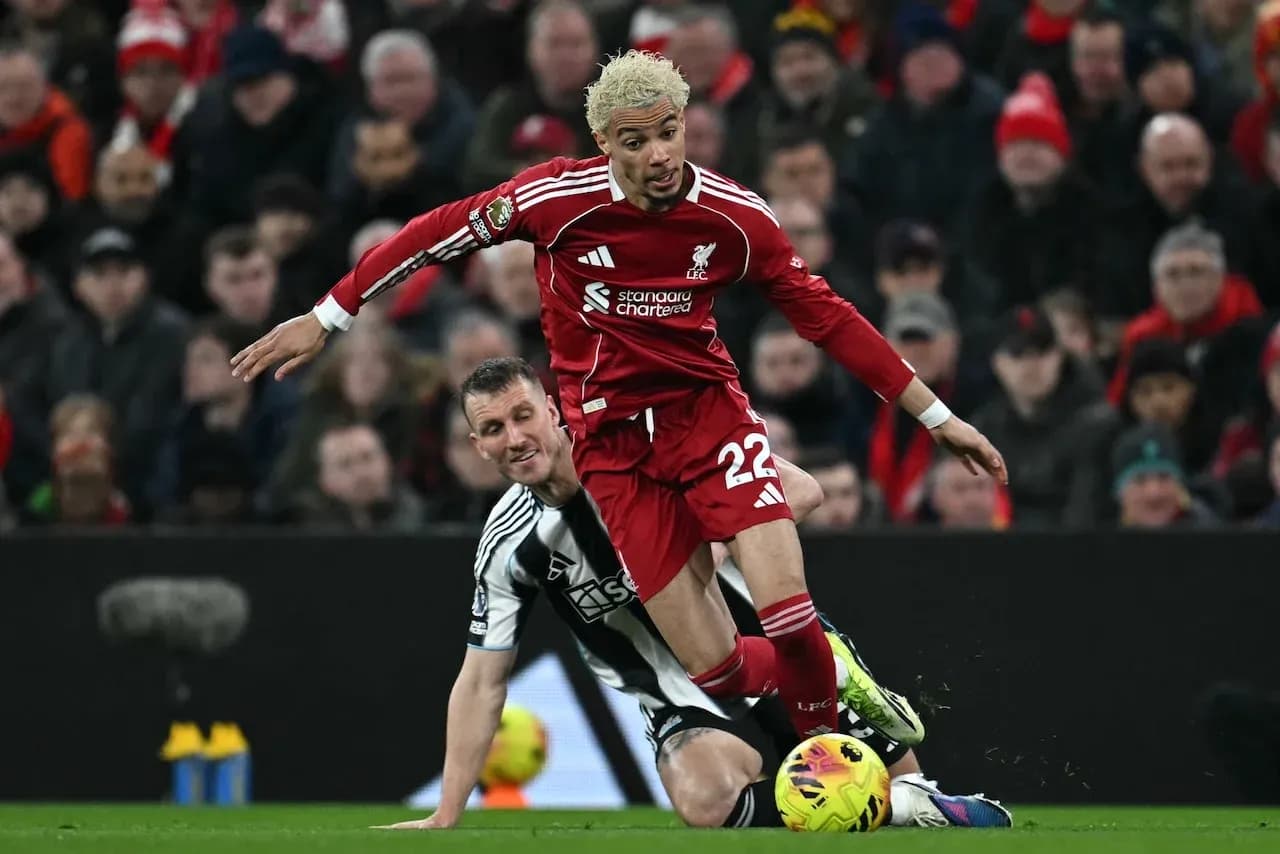 Liverpool player tackling Newcastle opponent during match