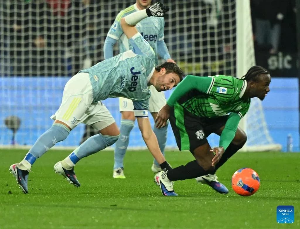 Sassuolo player challenges Juventus player for the ball