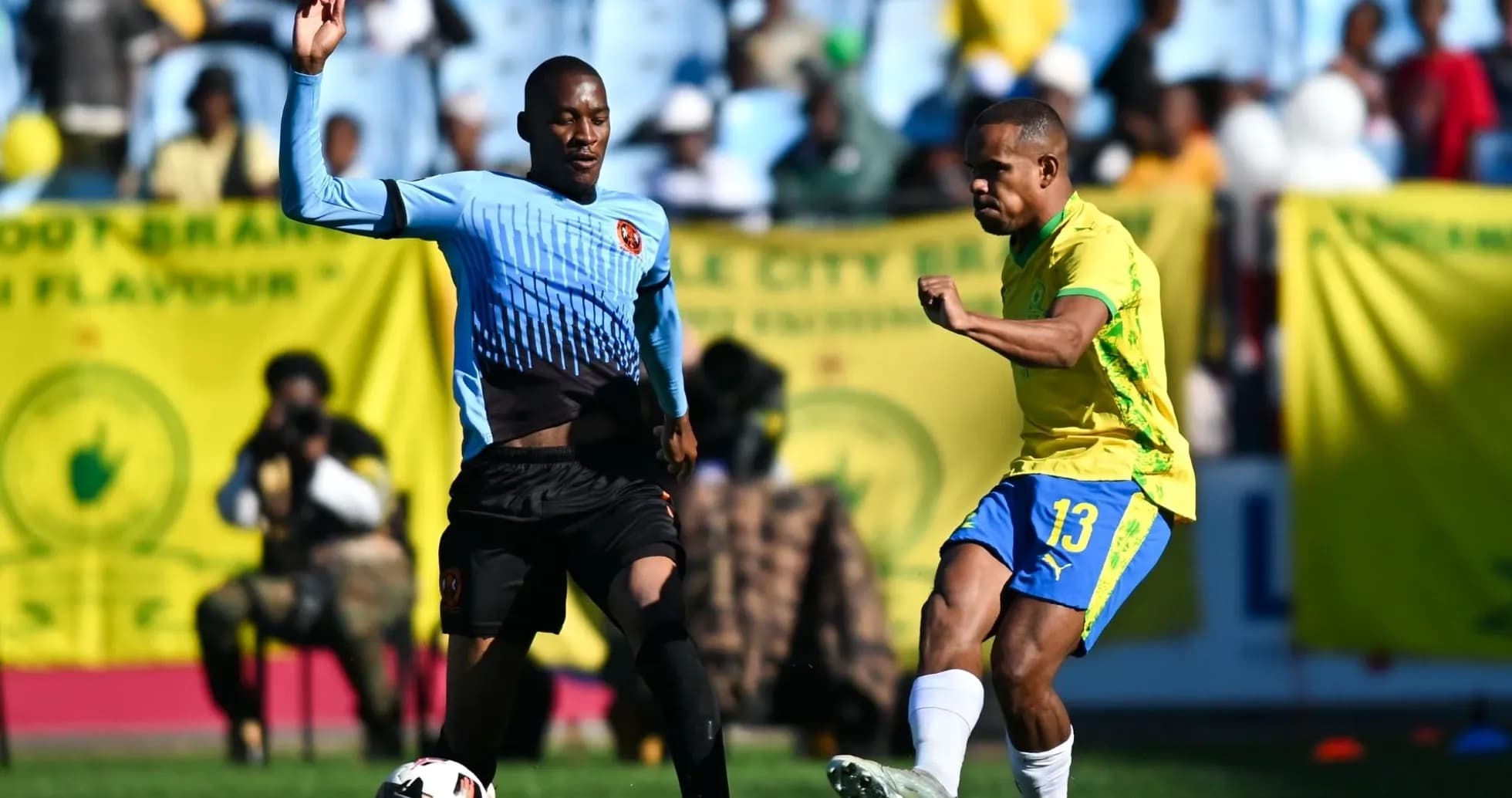 Player in yellow kicking ball while defender approaches