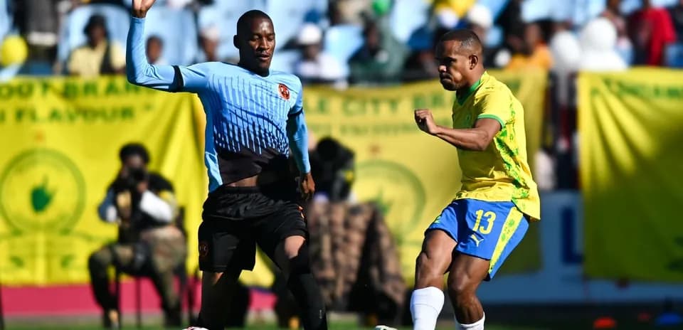 Player in yellow kicking ball while defender approaches