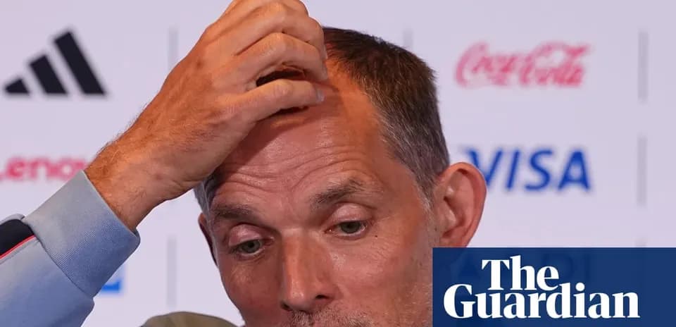 Coach speaking during press conference with hand on head