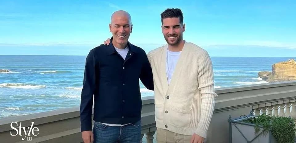 Two men posing together by the seaside