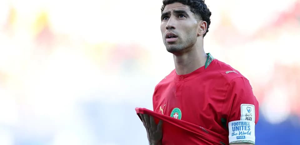 Player in red jersey holding shirt during match