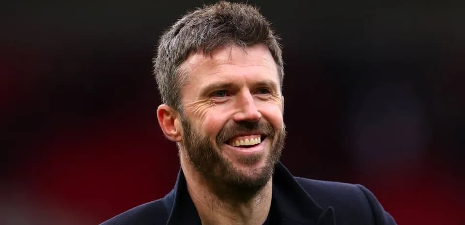 Man smiling in a dark jacket at stadium
