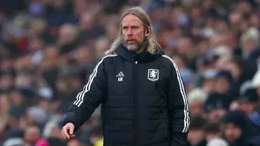 Coach in team jacket observing the match