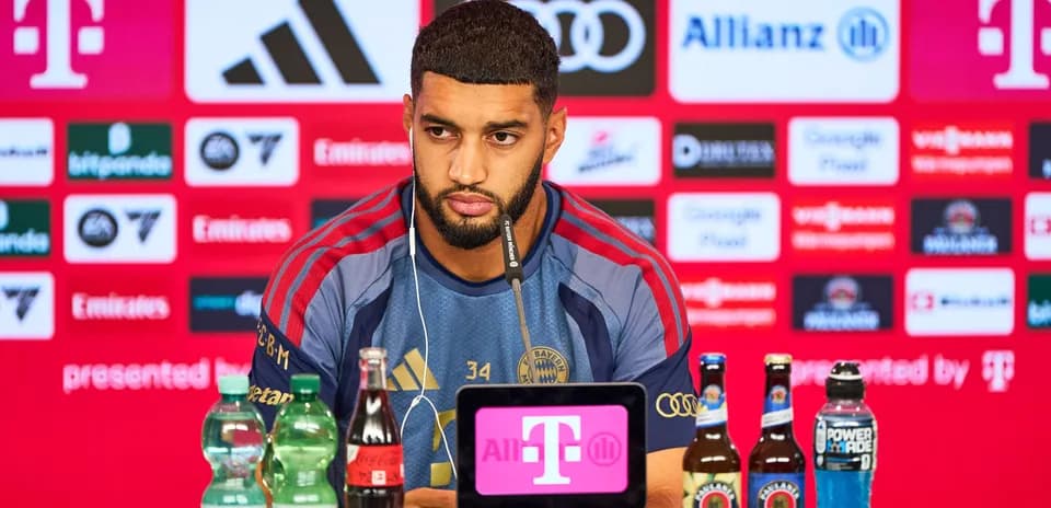 Player speaking at press conference with beverages on table