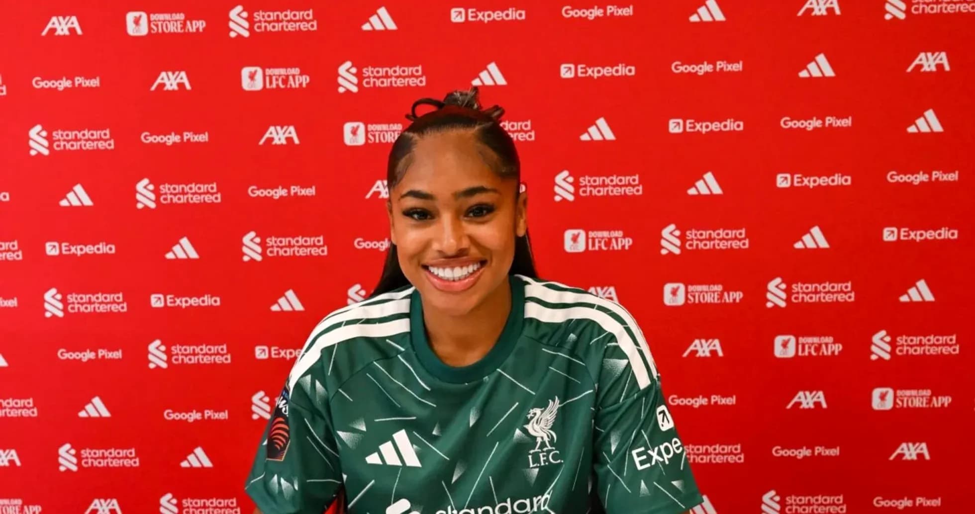 Player smiling during press conference in Liverpool kit