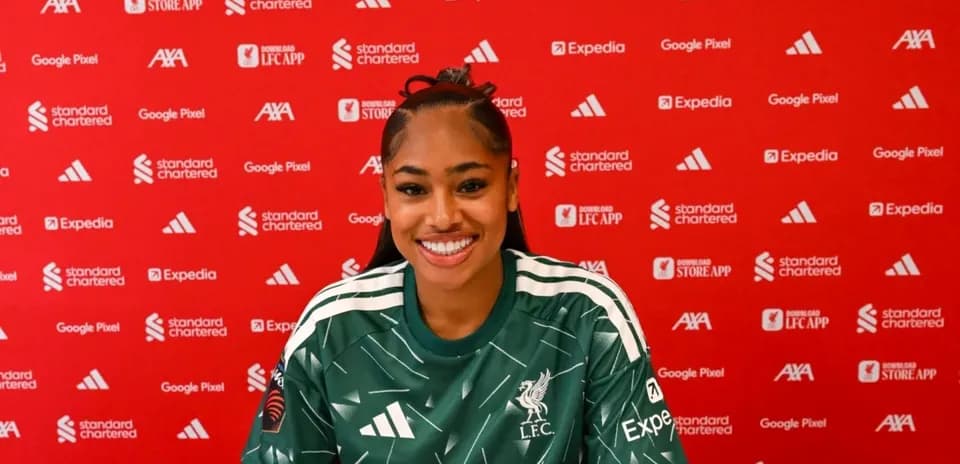 Player smiling during press conference in Liverpool kit