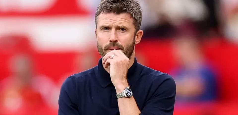 Coach observing the game with a thoughtful expression