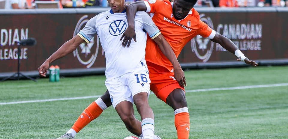 Two players competing for the ball in football match