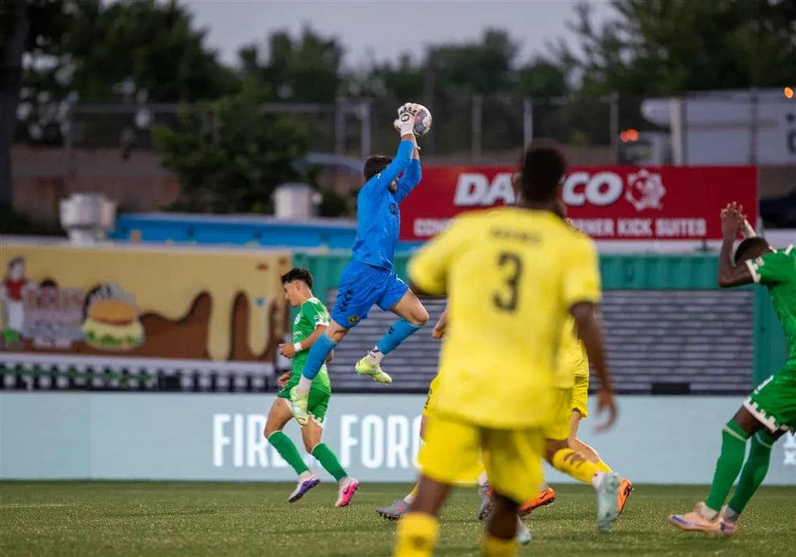 Goalkeeper catching the ball during match