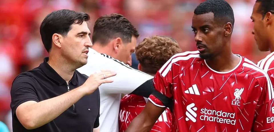 Coach discussing strategy with Liverpool player on field