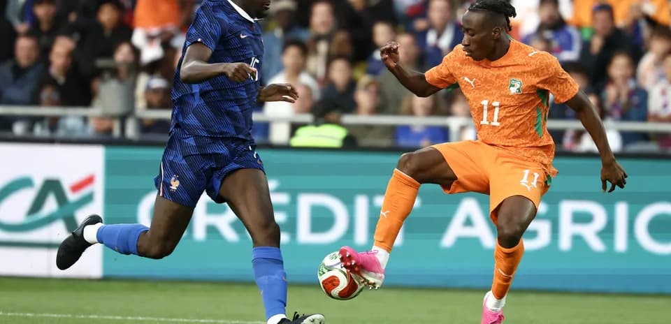 Player from France defending against Ivorian attacker