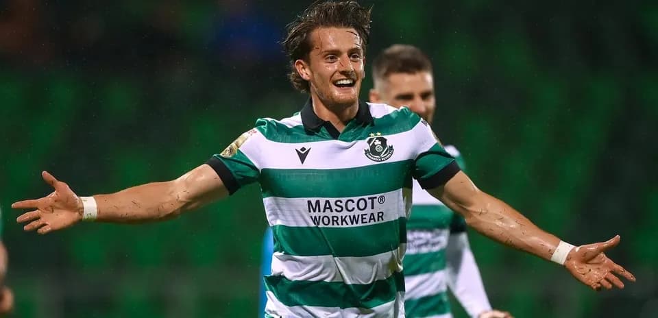 Player celebrating a goal in green and white kit
