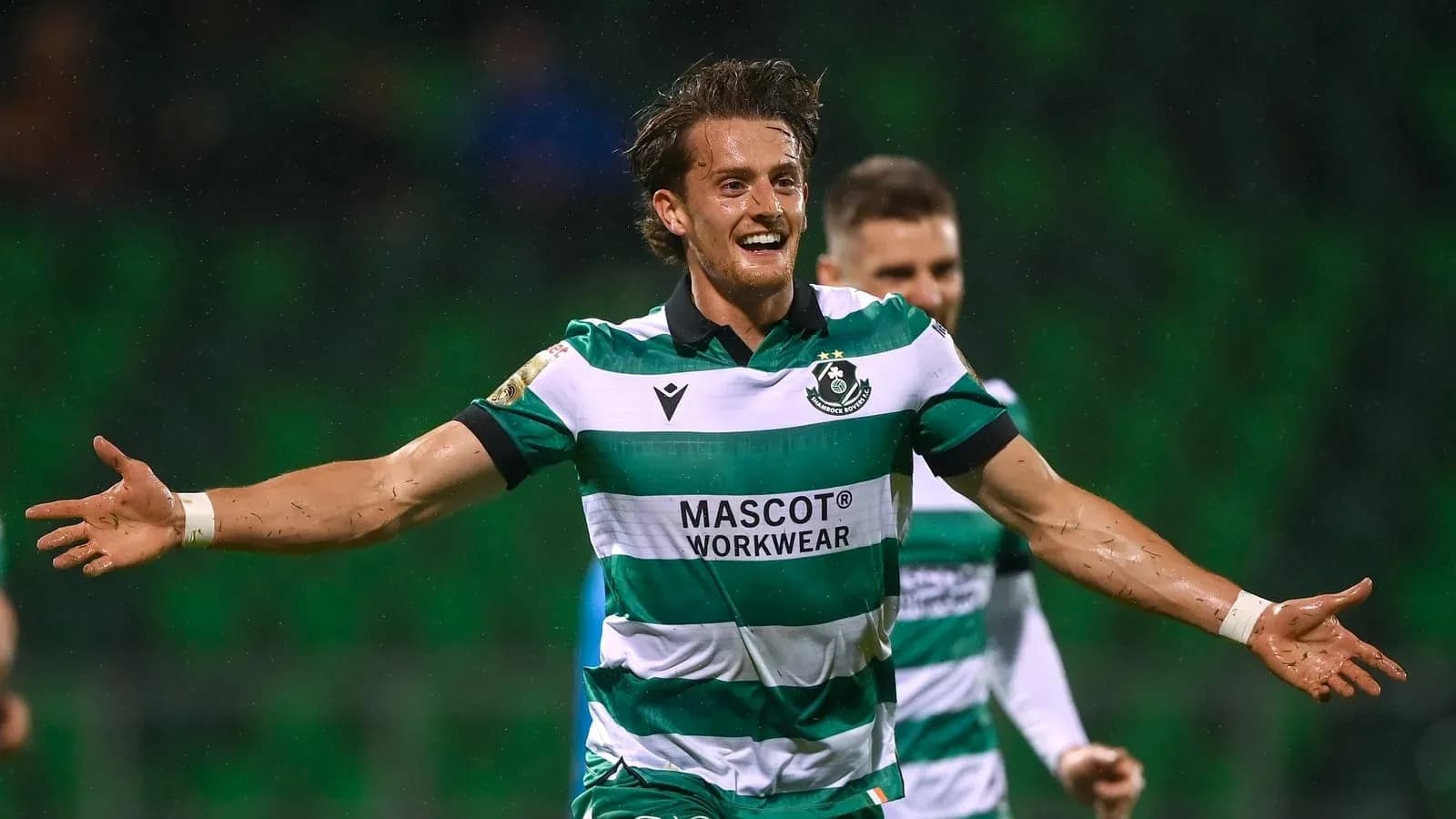Player celebrating a goal in green and white kit