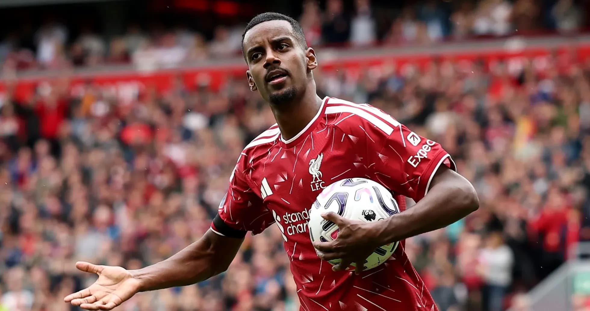 Player in Liverpool kit holding a football